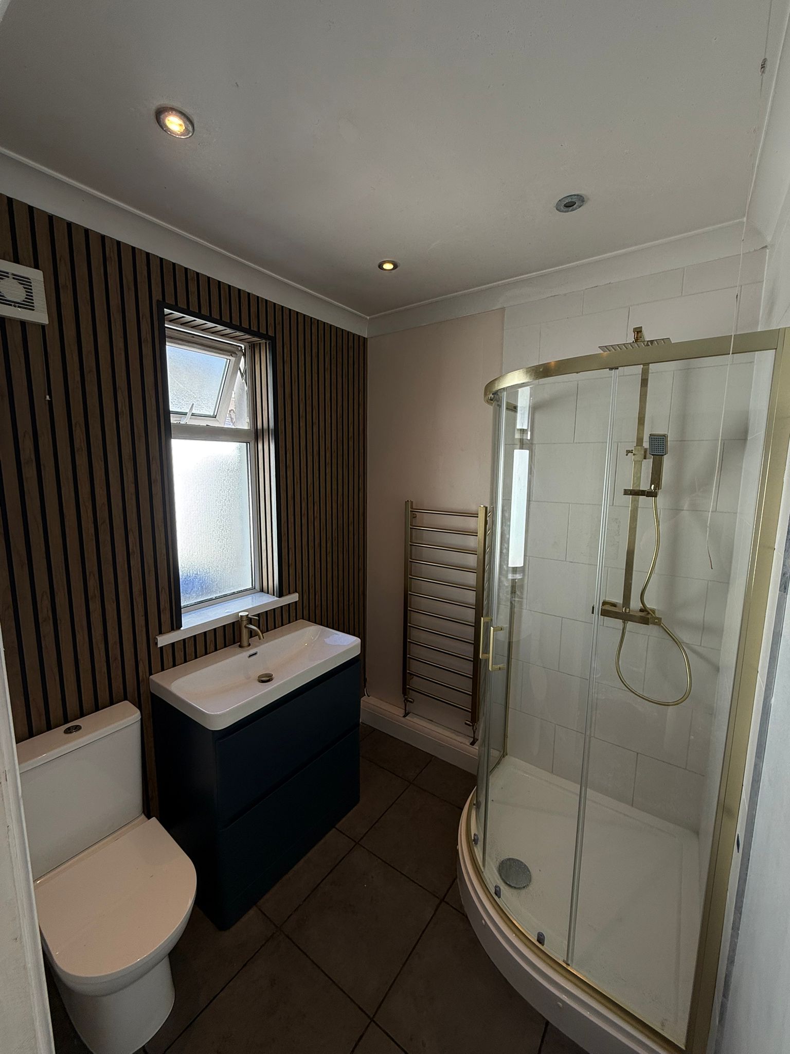 Finished bathroom refit with navy vanity unit and brass shower, Cardiff